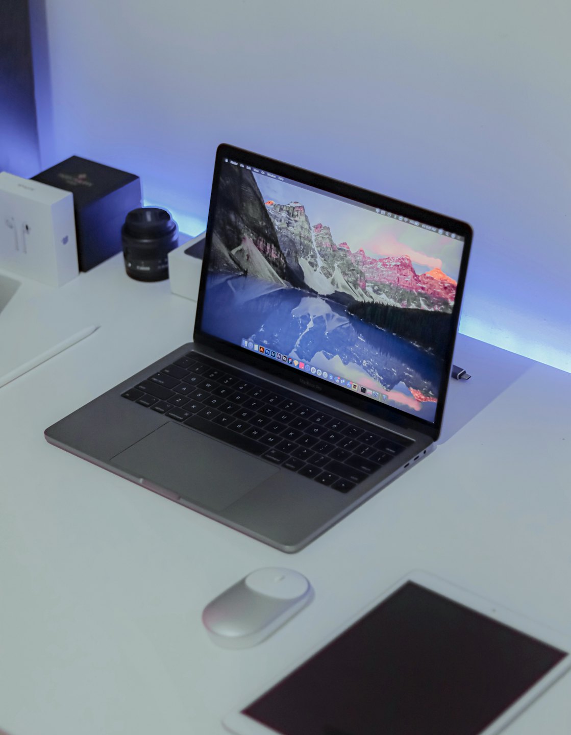 Laptop on a modern desk with tablet and stylus.